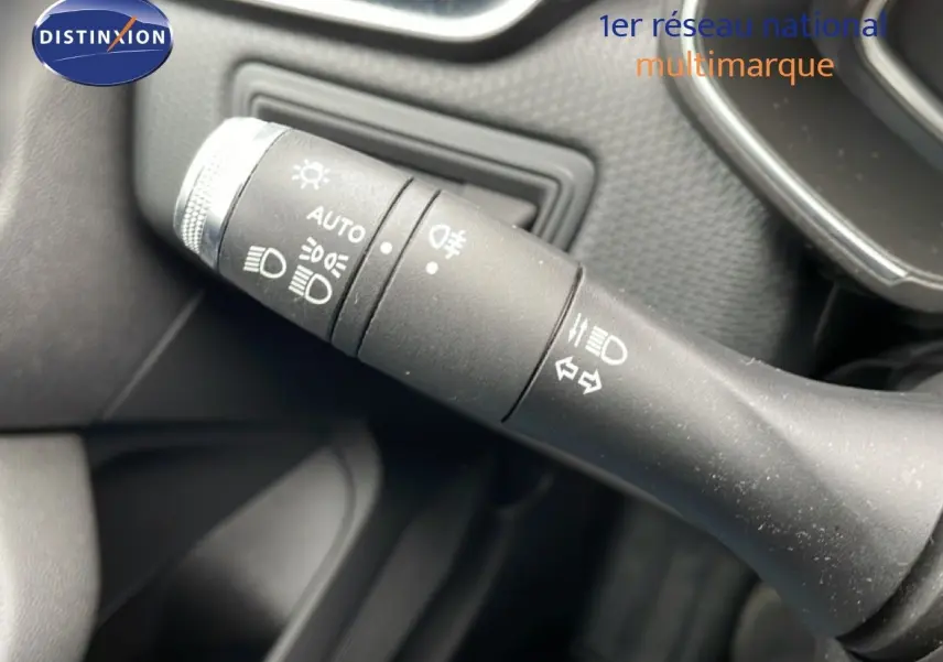 Gros plan sur la commande des phares et clignotants à gauche du volant d'une Renault Clio blanche Glacier 2020.