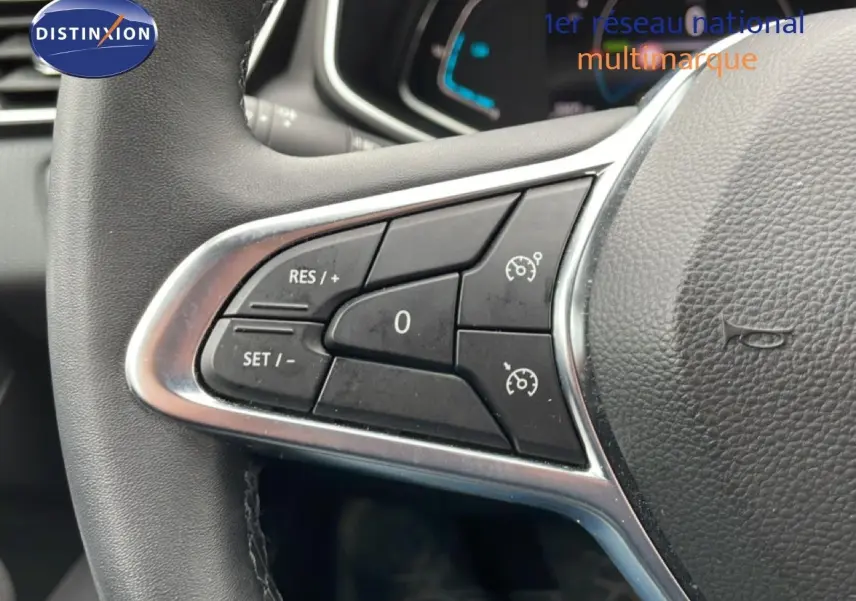 Gros plan sur les commandes de régulateur de vitesse au volant cuir d’une Renault Clio blanche Glacier 2020.
