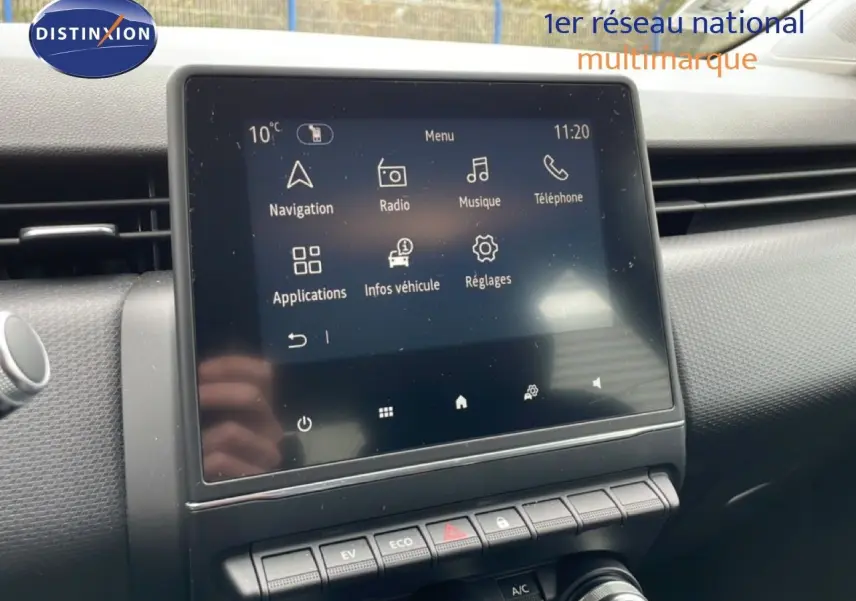 Écran tactile central de la Renault Clio blanc glacier, affichant le menu multimédia avec navigation et radio.