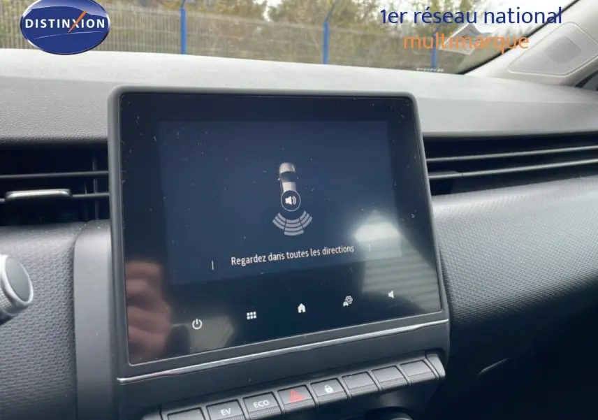 Vue rapprochée de l’écran tactile central du tableau de bord de la Renault Clio blanche, affichant une alerte de surveillance.