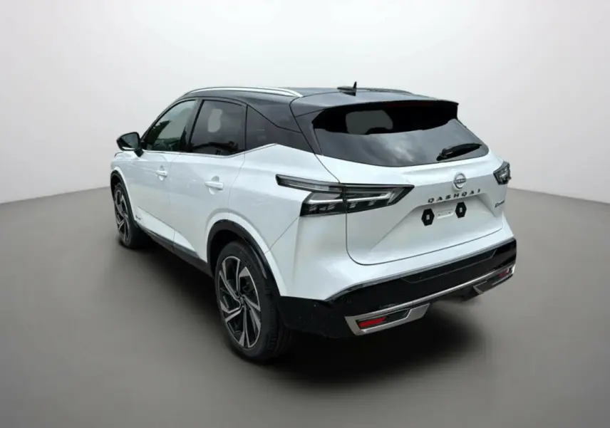 Vue 3/4 arrière droite du Nissan Qashqai blanc lunaire avec toit noir et jantes alu 20 pouces sur fond neutre.