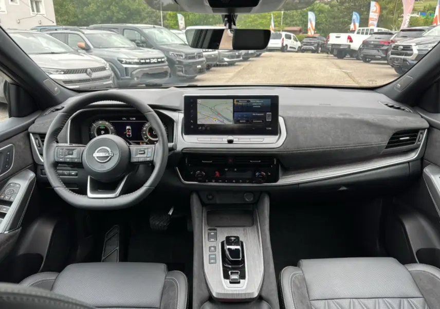 Vue intérieure avant du Nissan Qashqai E-POWER 205 Tekna Plus avec tableau de bord moderne et écran tactile central.