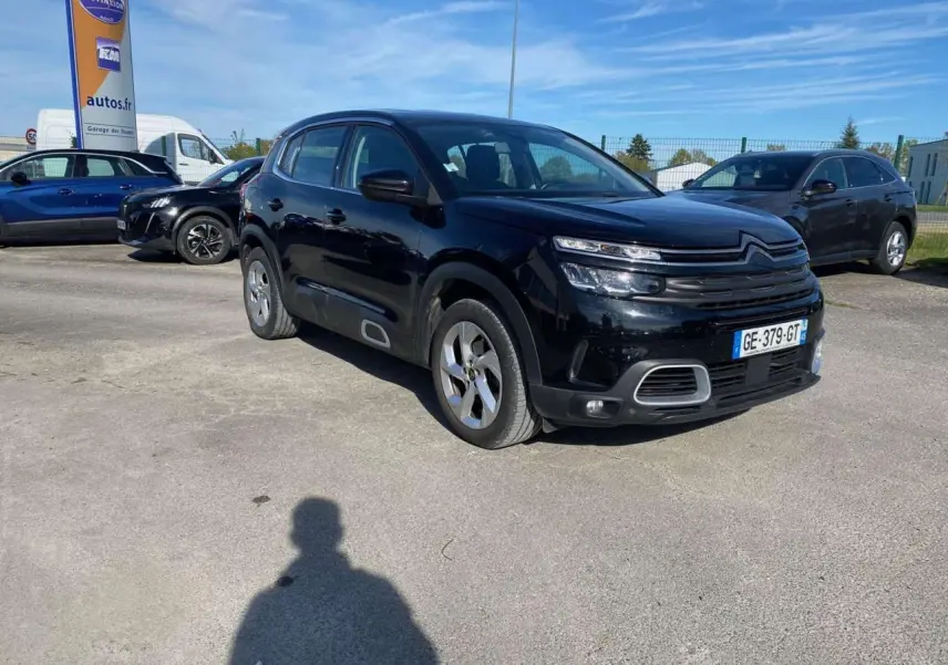 Citroën C5 Aircross noir vue 3/4 avant droit sur parking avec jantes alliage 18 pouces et calandre distinctive.