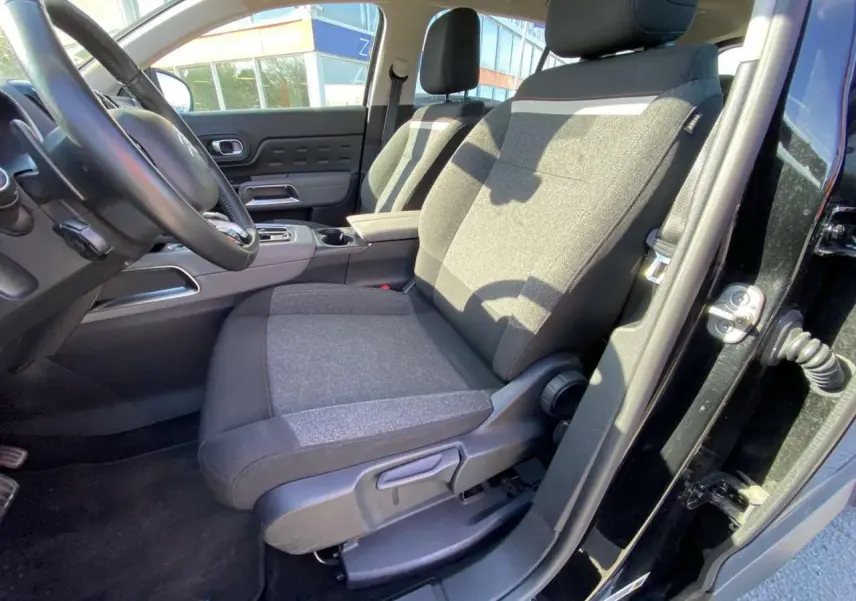 Vue intérieure côté conducteur du Citroën C5 Aircross noir 2021, mettant en valeur le siège avant en tissu gris et noir.