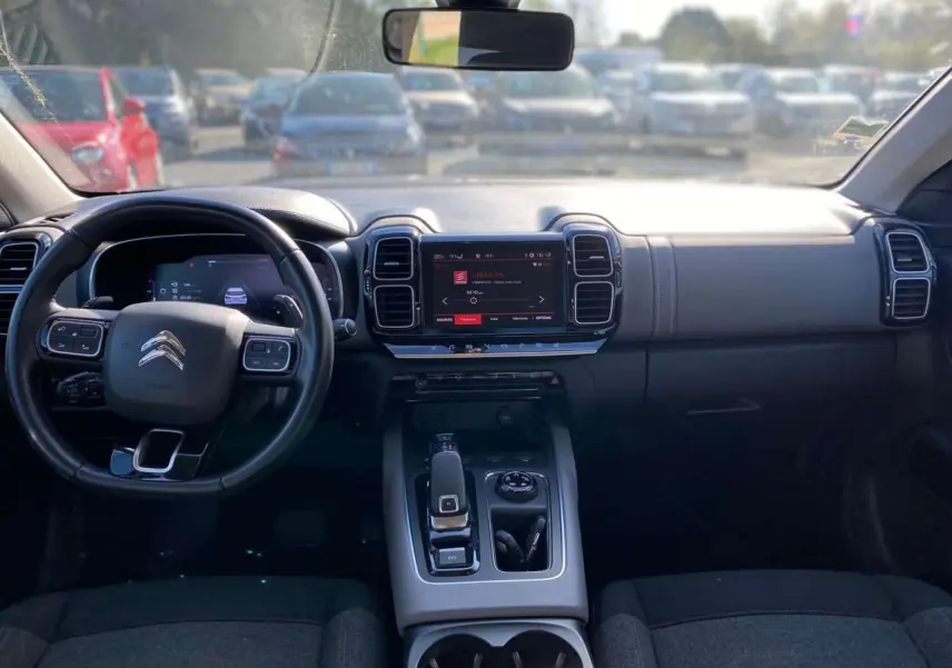 Vue intérieure avant du Citroën C5 Aircross 2021, tableau de bord noir avec écran tactile et volant multifonction.