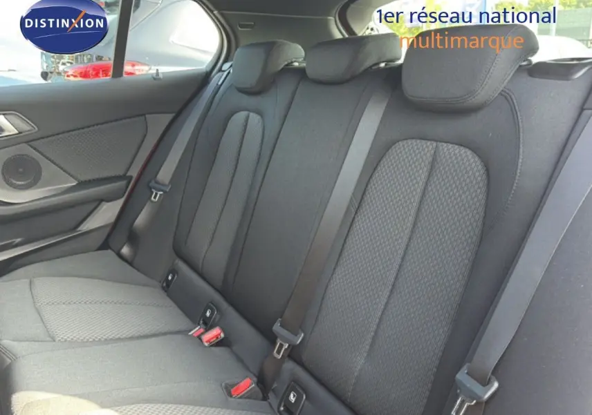 Vue intérieure des sièges arrière en tissu gris foncé de la BMW Série 1 116i Business, avec ceintures de sécurité visibles.