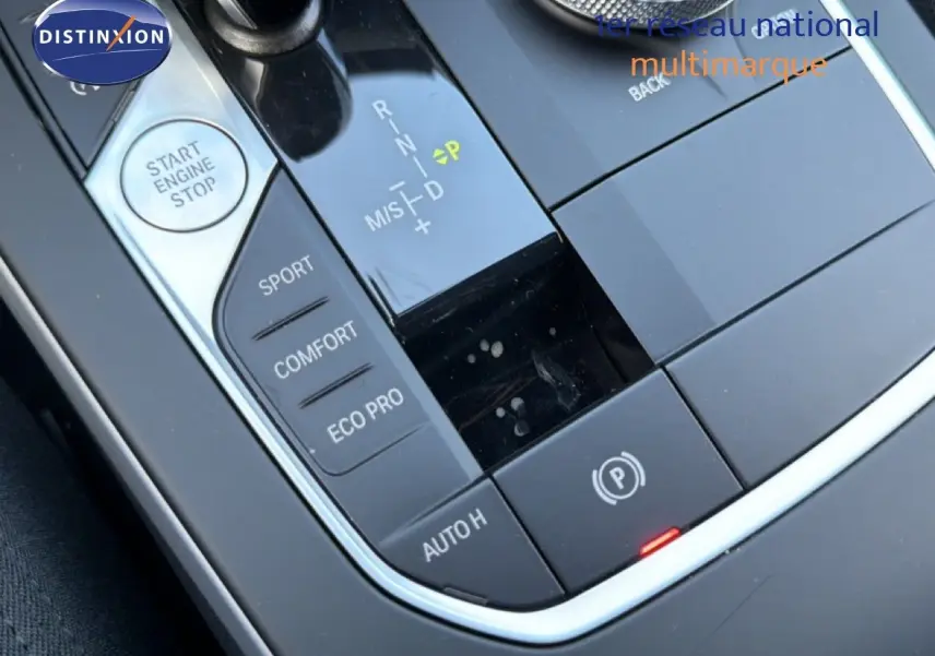 Gros plan sur la console centrale noire de la BMW Série 1 116i 2022, montrant le levier de vitesses automatique et les modes de conduite.