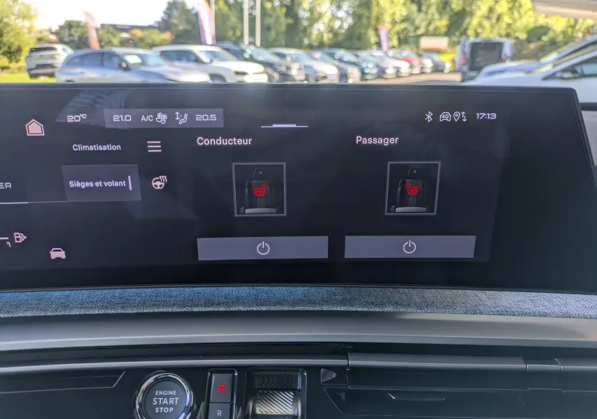 Écran tactile intérieur du Peugeot 3008 Hybrid 145 GT montrant le réglage des sièges chauffants, avec tableau de bord et bouton start visible.