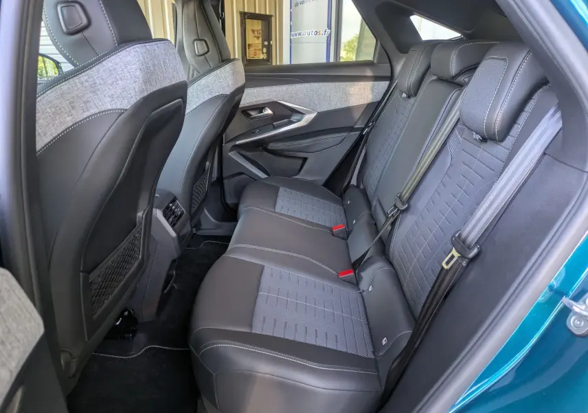 Vue intérieure côté droit des sièges arrière du Peugeot 3008 Hybrid 145 GT avec sellerie tissu gris et cuir noir.