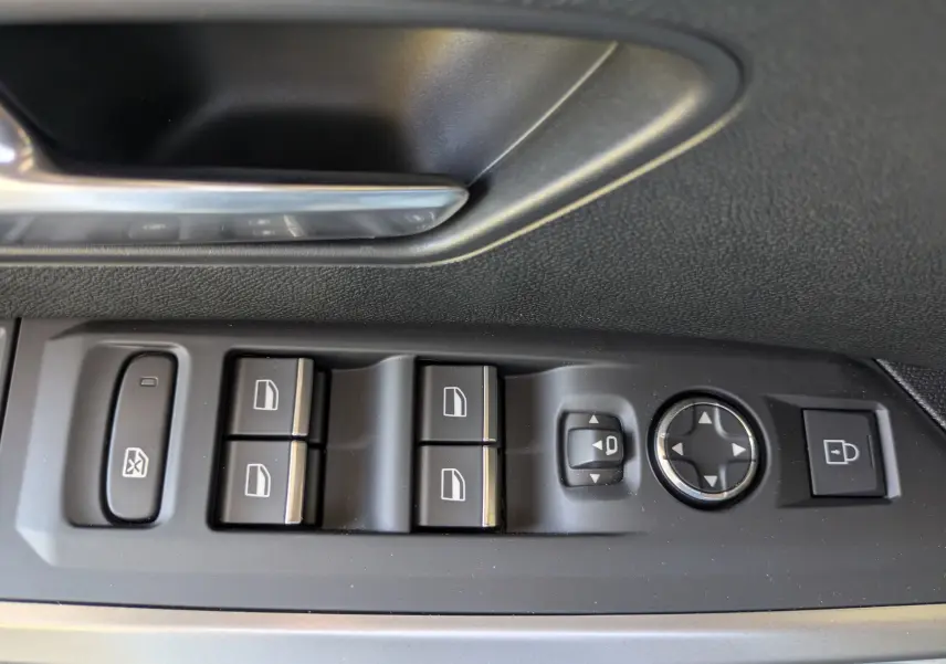 Gros plan sur les commandes des vitres et rétroviseurs côté conducteur du Peugeot 3008 Hybrid 145 GT, intérieur noir.