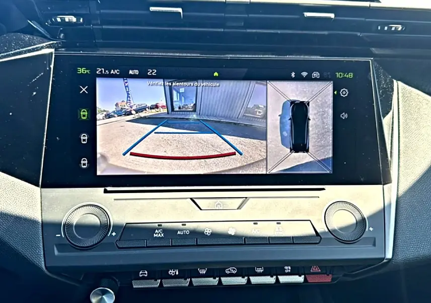 Écran tactile central de la Peugeot 408 Hybrid 145 allure noir montrant la caméra de recul et vue à 360° du véhicule.