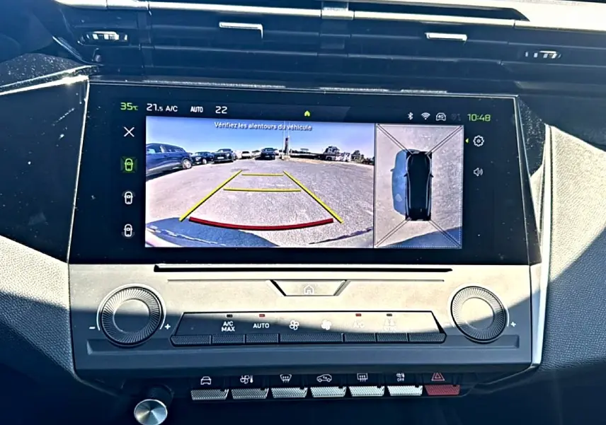 Vue rapprochée de l'écran tactile central du Peugeot 408 Hybrid 145 allure noir, affichant la caméra de recul et la vue à 360°.