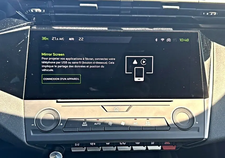 Écran tactile central de la Peugeot 408 Hybrid 145 allure noir, vue frontale du tableau de bord avec commandes clim.