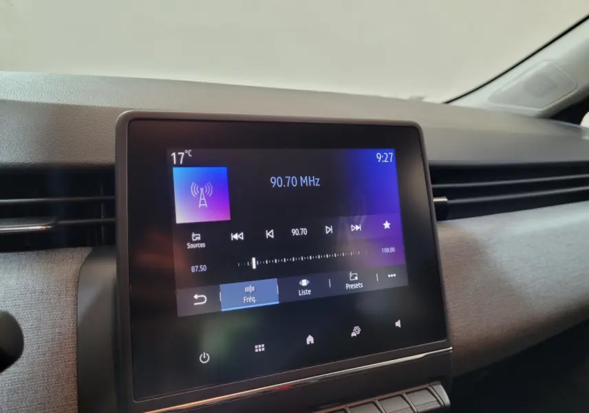 Écran tactile central de 17,8 cm affichant la radio dans l’habitacle d’une Renault Clio gris foncé, vue de face.