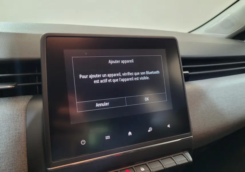 Écran tactile central affichant un message Bluetooth dans l'habitacle gris clair d'une Renault Clio Evolution 2025.