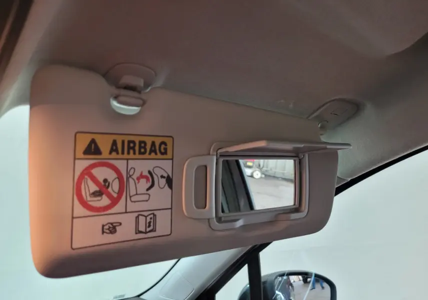 Détail du pare-soleil côté conducteur avec miroir intégré et avertissement airbag dans une Renault Clio gris foncé, vue intérieure.