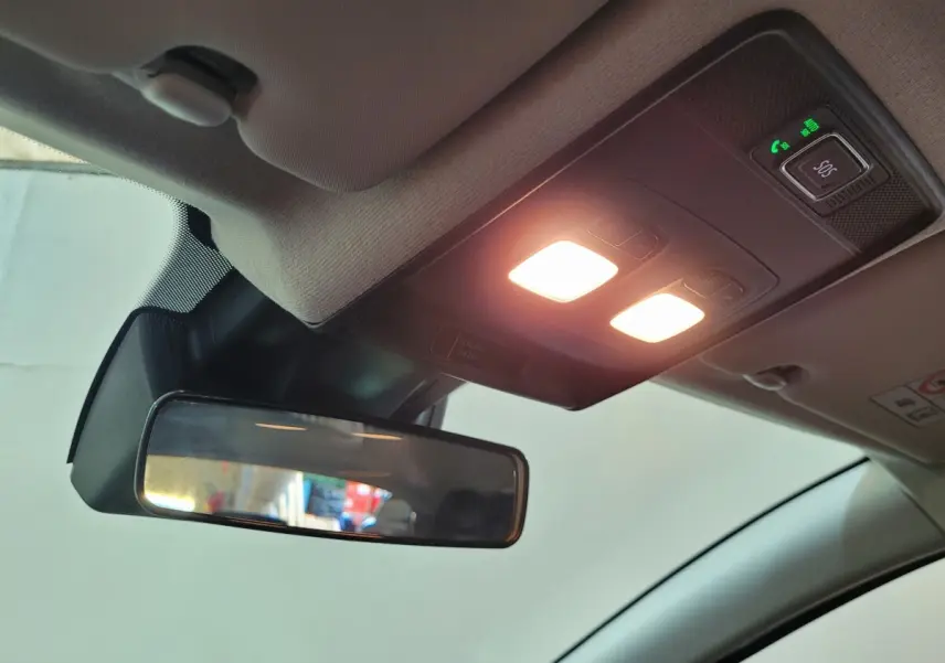 Vue intérieure du plafonnier et du rétroviseur intérieur de la Renault Clio gris foncé, avec éclairage activé.