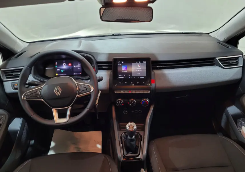 Vue intérieure avant du tableau de bord gris foncé de la Renault Clio Evolution Blue dCi 100 avec volant cuir et écran tactile central.
