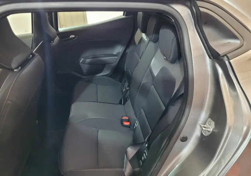 Vue intérieure côté droit sur la banquette arrière noire d’une Renault Clio gris foncé avec ceinture de sécurité visible.