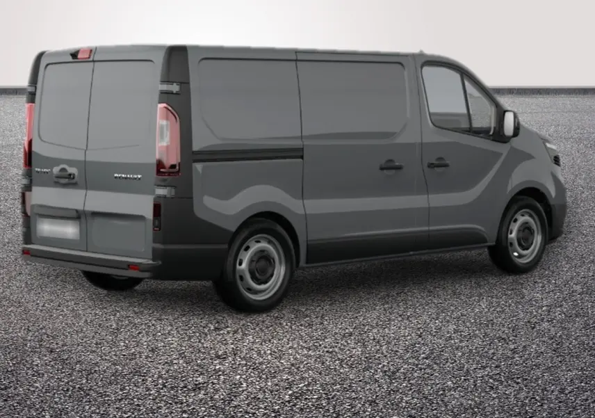 Vue 3/4 arrière droite d’un Renault Trafic Fourgon gris foncé avec portes arrière fermées sur sol gravillonné.