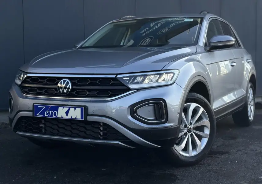 Volkswagen T-Roc gris Indium en 3/4 avant droit, avec calandre noire et jantes alliage visibles.
