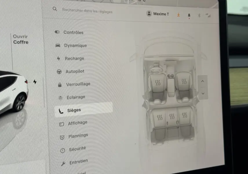Écran tactile central montrant les réglages des sièges chauffants d’une Tesla Model Y blanche, vue intérieure.