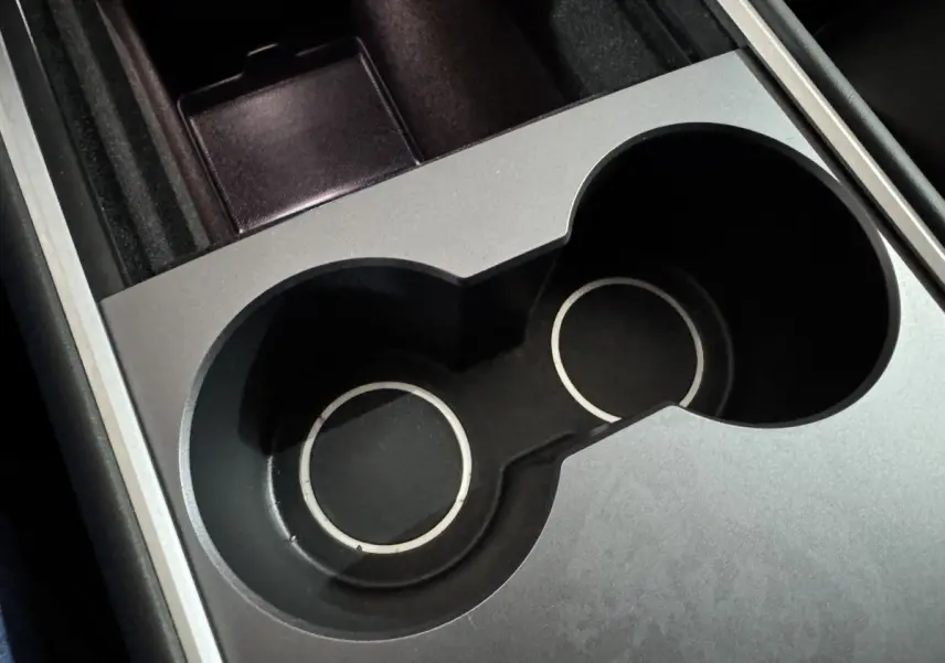 Gros plan sur les porte-gobelets noirs et argentés du Tesla Model Y Grand Autonomie intérieur.