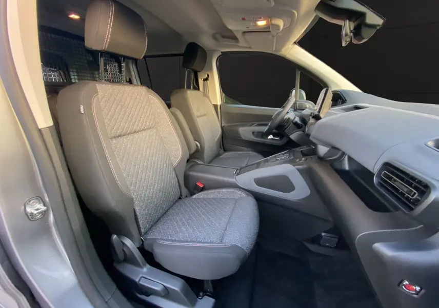 Vue intérieure côté droit du Peugeot Rifter gris acier 2026, montrant les sièges avant et le tableau de bord.