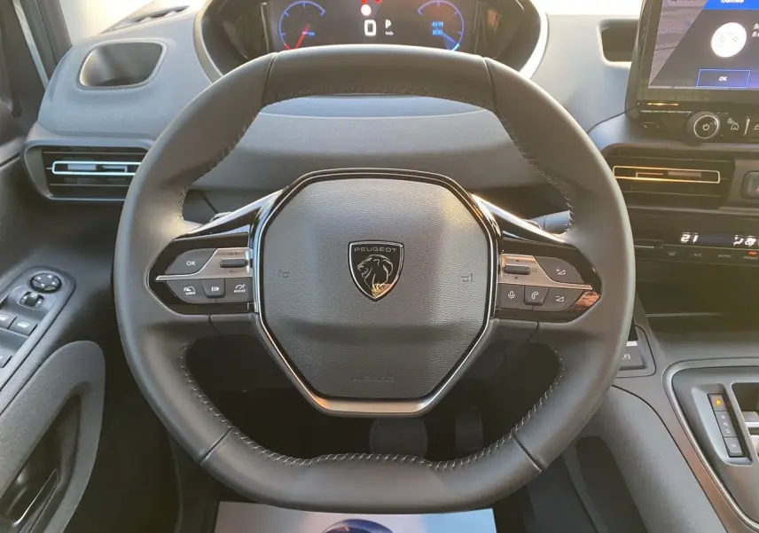Vue rapprochée du volant cuir noir du Peugeot Rifter 2026 avec tableau de bord numérique et écran tactile central.