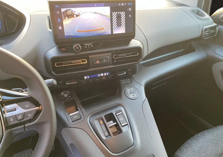 Vue intérieure du tableau de bord et console centrale du Peugeot Rifter gris acier, avec écran tactile et caméra de recul affichée.