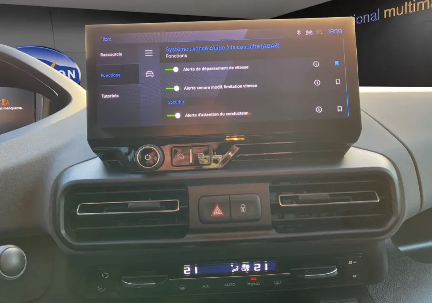 Écran tactile central affichant les aides à la conduite du Peugeot Rifter gris acier, vue intérieure frontale.