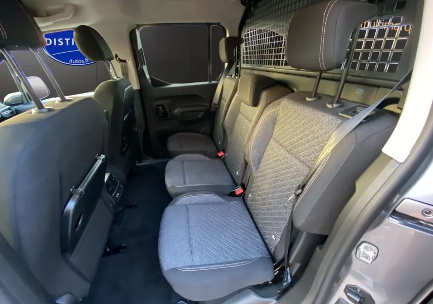 Vue intérieure côté droit sur les sièges arrière gris avec grille de séparation du Peugeot Rifter N1 M 2026.