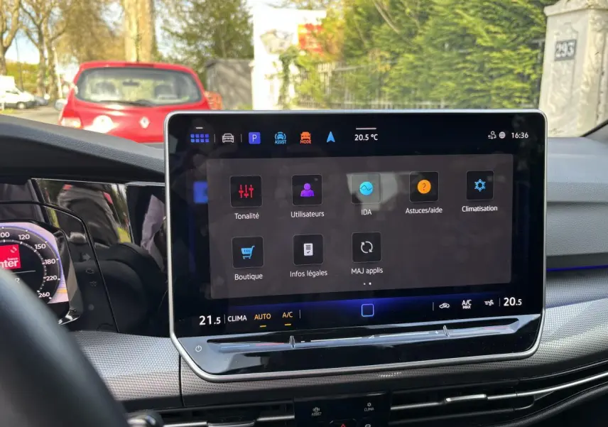 Vue intérieure centrée sur l'écran tactile du tableau de bord d'une Volkswagen Golf blanche, Edition 50, 2024.