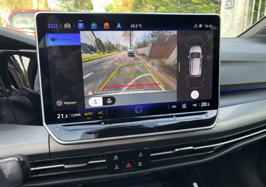 Écran tactile intérieur de la Volkswagen Golf 2024 blanc montrant la caméra de recul avec guidage de trajectoire.