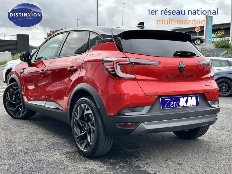 Vue 3/4 arrière droite du Renault Captur 2025 hybride Rouge Flamme avec toit et détails noirs, jantes noires distinctives.