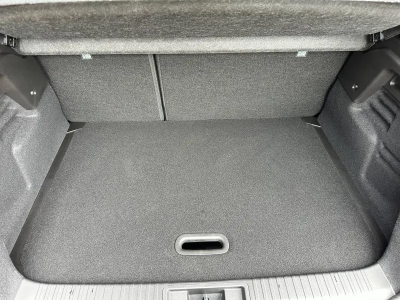 Coffre ouvert vu de face du Renault Captur 1.6 E-Tech hybride 2025, intérieur de coffre gris foncé sans chargement visible.