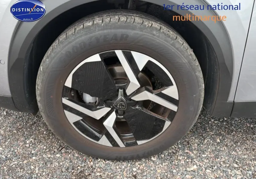 Gros plan sur la jante alu noire et argentée du côté avant droit d’un Peugeot 2008 gris Artense.