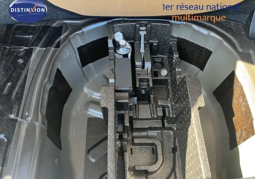 Gros plan sur le coffre d’une Skoda Fabia noire, montrant le rangement pour roue de secours et outils intégrés.