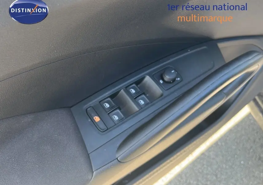 Gros plan sur la commande des vitres électriques côté conducteur d'une Skoda Fabia noir magique métal, intérieur tissu gris-noir.