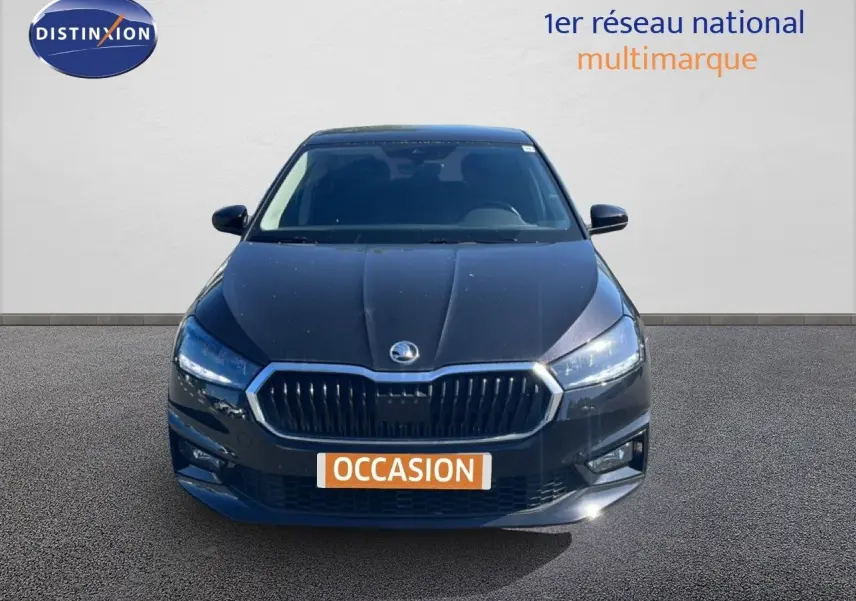 Vue avant d'une Skoda Fabia 2025 noire métallisée avec calandre chromée et phares LED allumés.