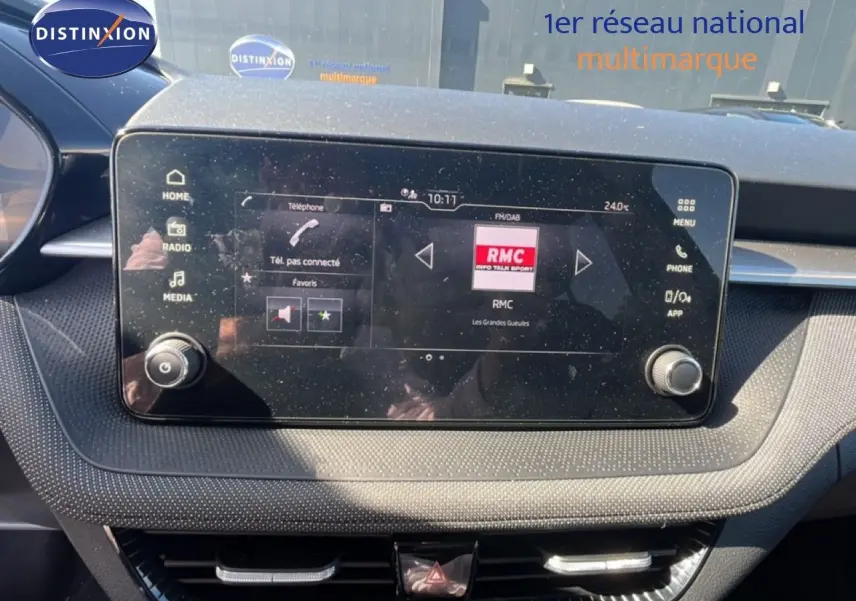 Écran tactile central du tableau de bord de la Skoda Fabia 2025, affichant la radio RMC, avec finition intérieure gris noir.