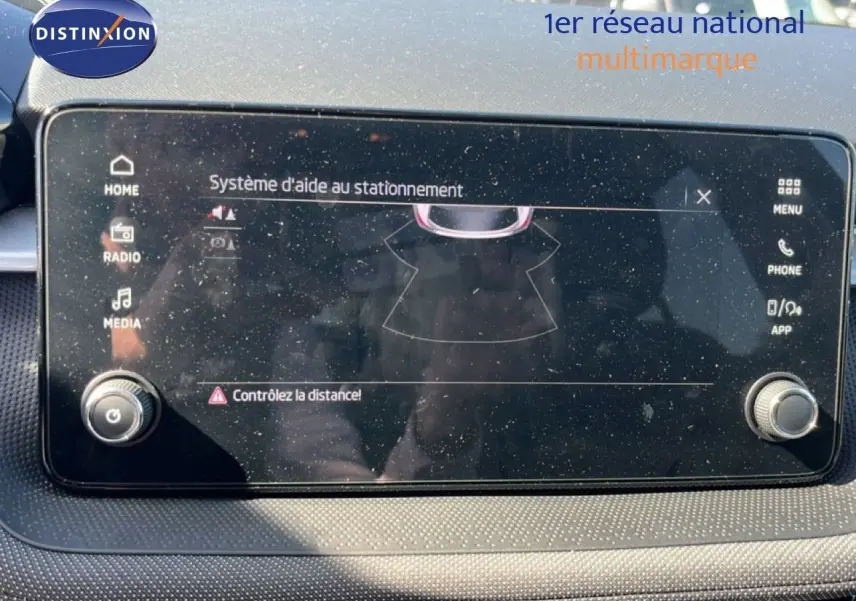 Écran tactile du système d'aide au stationnement de la Skoda Fabia 2025, vue rapprochée du tableau de bord noir.