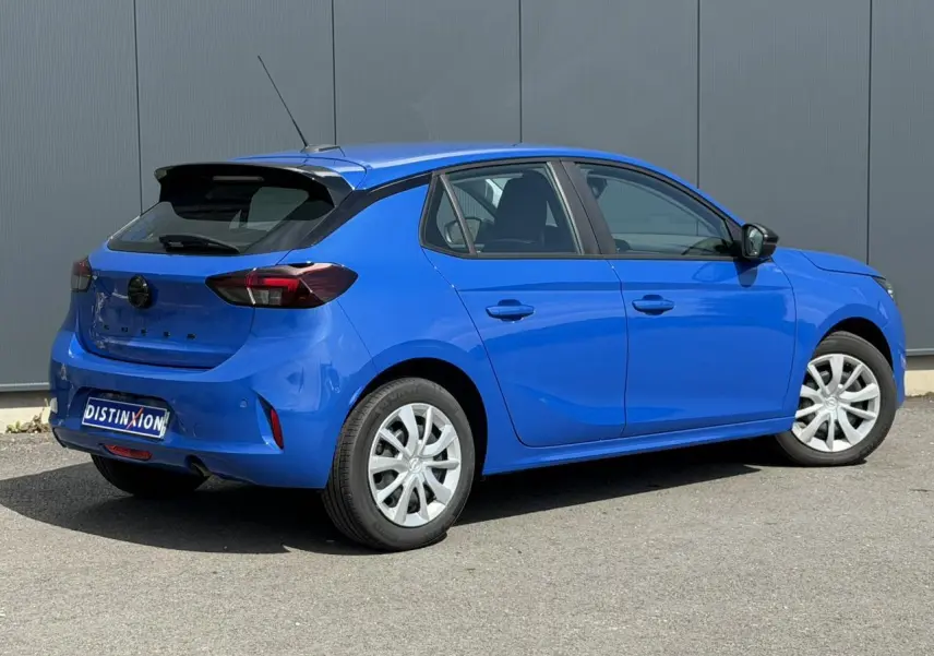 Opel Corsa bleu Voltaic vue 3/4 arrière droit, avec feux arrière fumés et jantes blanches.