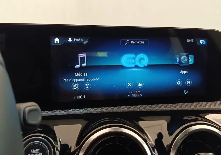 Vue rapprochée de l'écran tactile multimédia et des aérateurs ronds du tableau de bord d'une Mercedes Classe A noire.