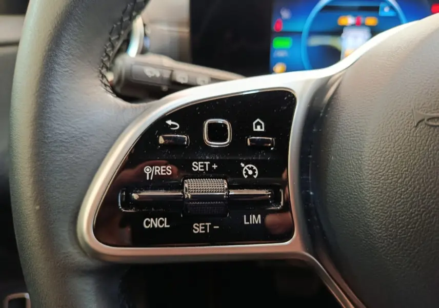 Gros plan sur le volant cuir noir de la Mercedes Classe A 250 e Business Line 2022, avec commandes multifonctions visibles.
