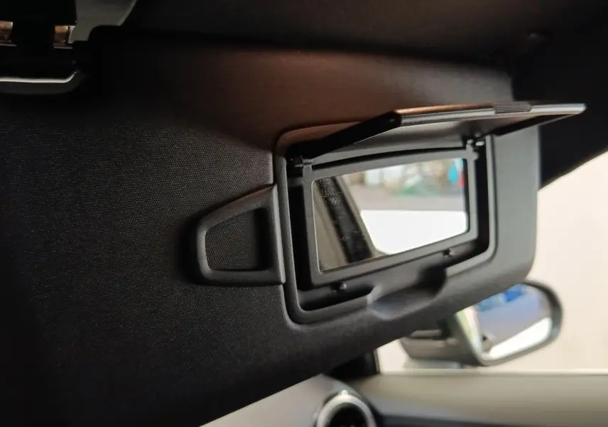 Détail du miroir de courtoisie ouvert sur le pare-soleil côté conducteur d’une Mercedes Classe A noire, intérieur visible.
