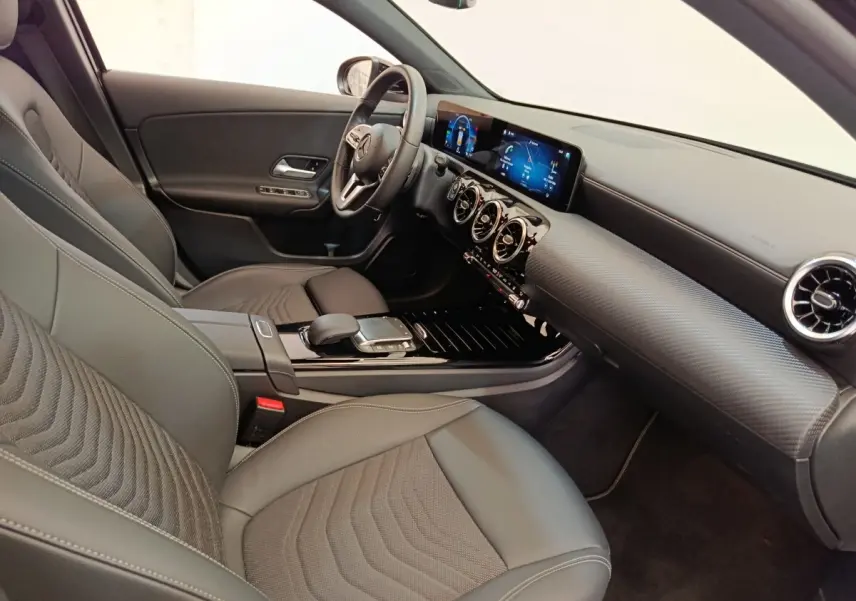 Vue intérieure côté conducteur de la Mercedes Classe A 250 e Business Line 2022 avec sièges cuir noirs et tableau de bord numérique.