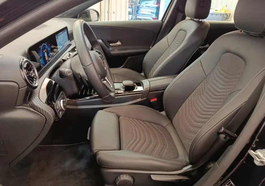 Intérieur noir de la Mercedes Classe A 250 e Business Line 2022, vue côté conducteur avec sièges et tableau de bord.