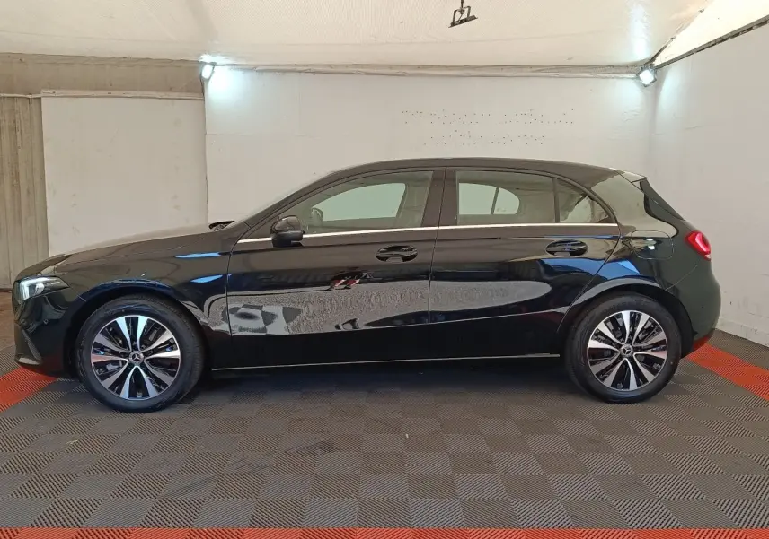 Profil latéral gauche d'une Mercedes Classe A 250 e Business Line noire, avec jantes alliage et poignées de porte intégrées.
