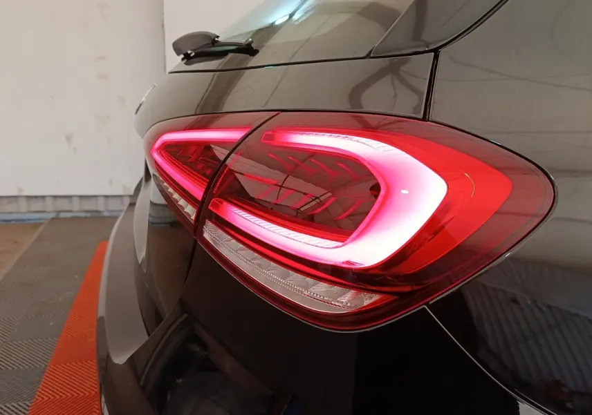 Gros plan sur le feu arrière droit allumé d’une Mercedes Classe A noire, vue depuis l’arrière côté droit.